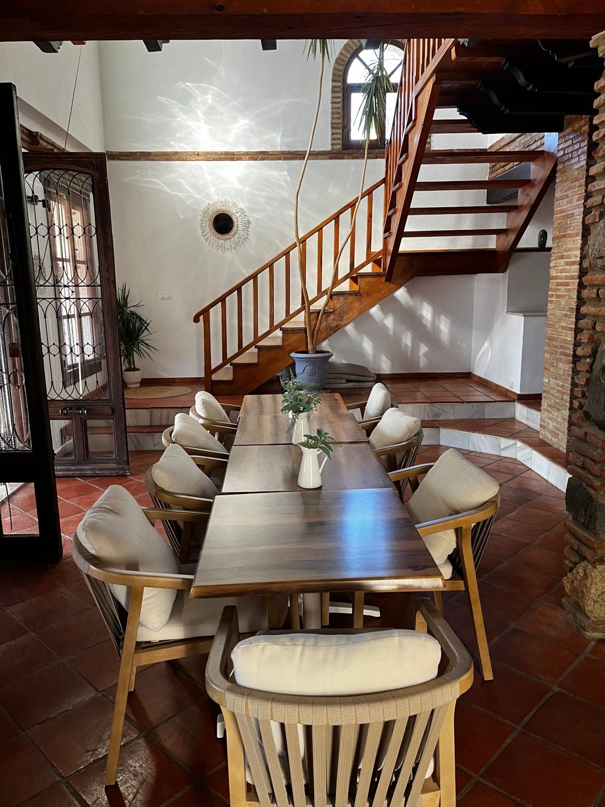 Dining room with a long wooden table set for the group