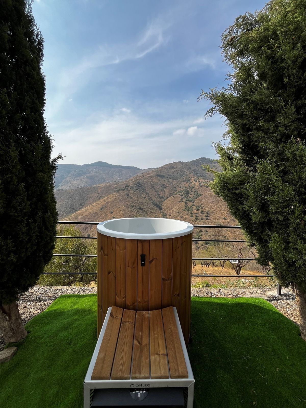 Ice bath between cypress trees, facing the mountains